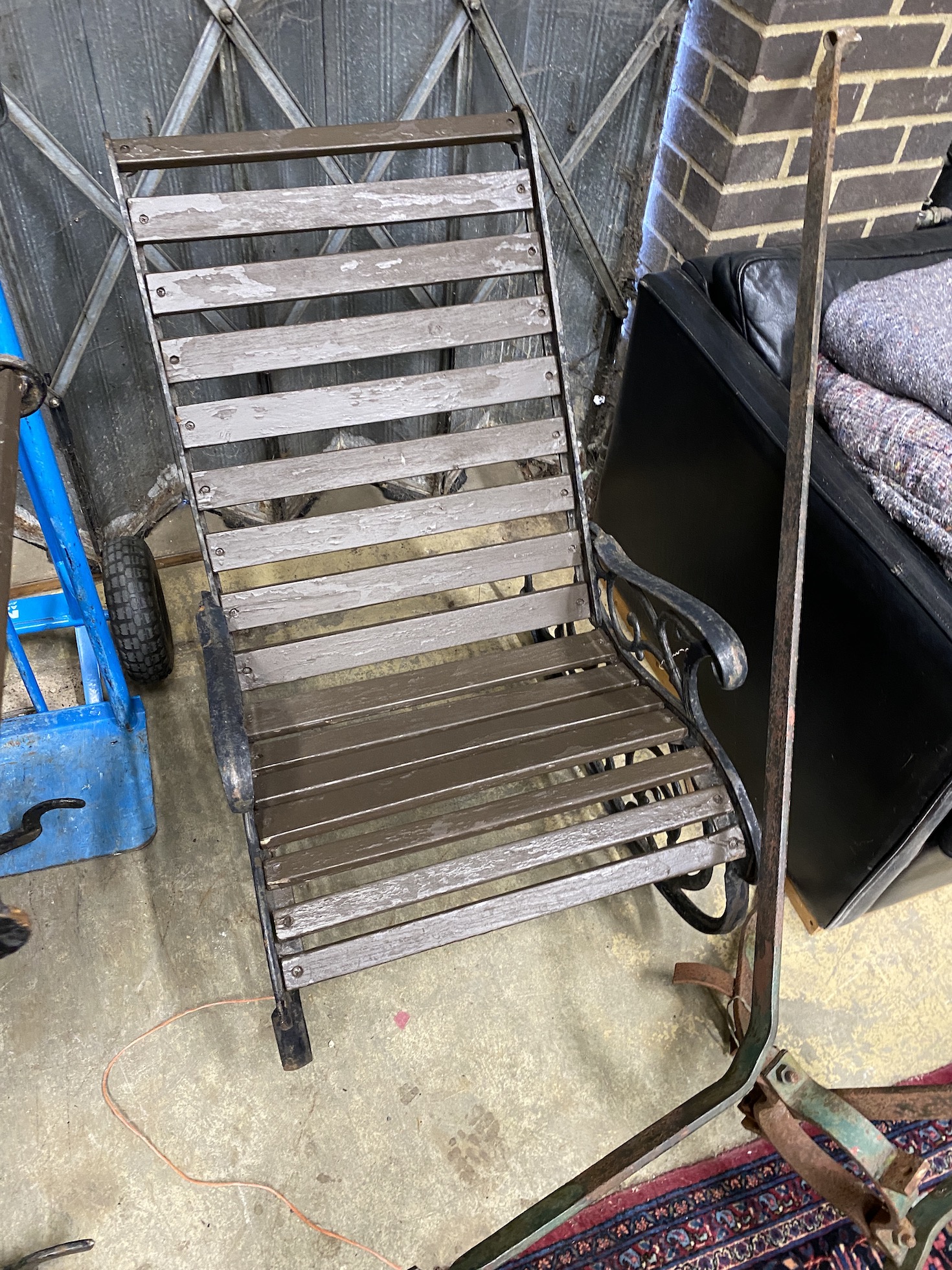 A pair of cast metal slatted wood rocking garden chairs, width 62cm, depth 86cm, height 88cm